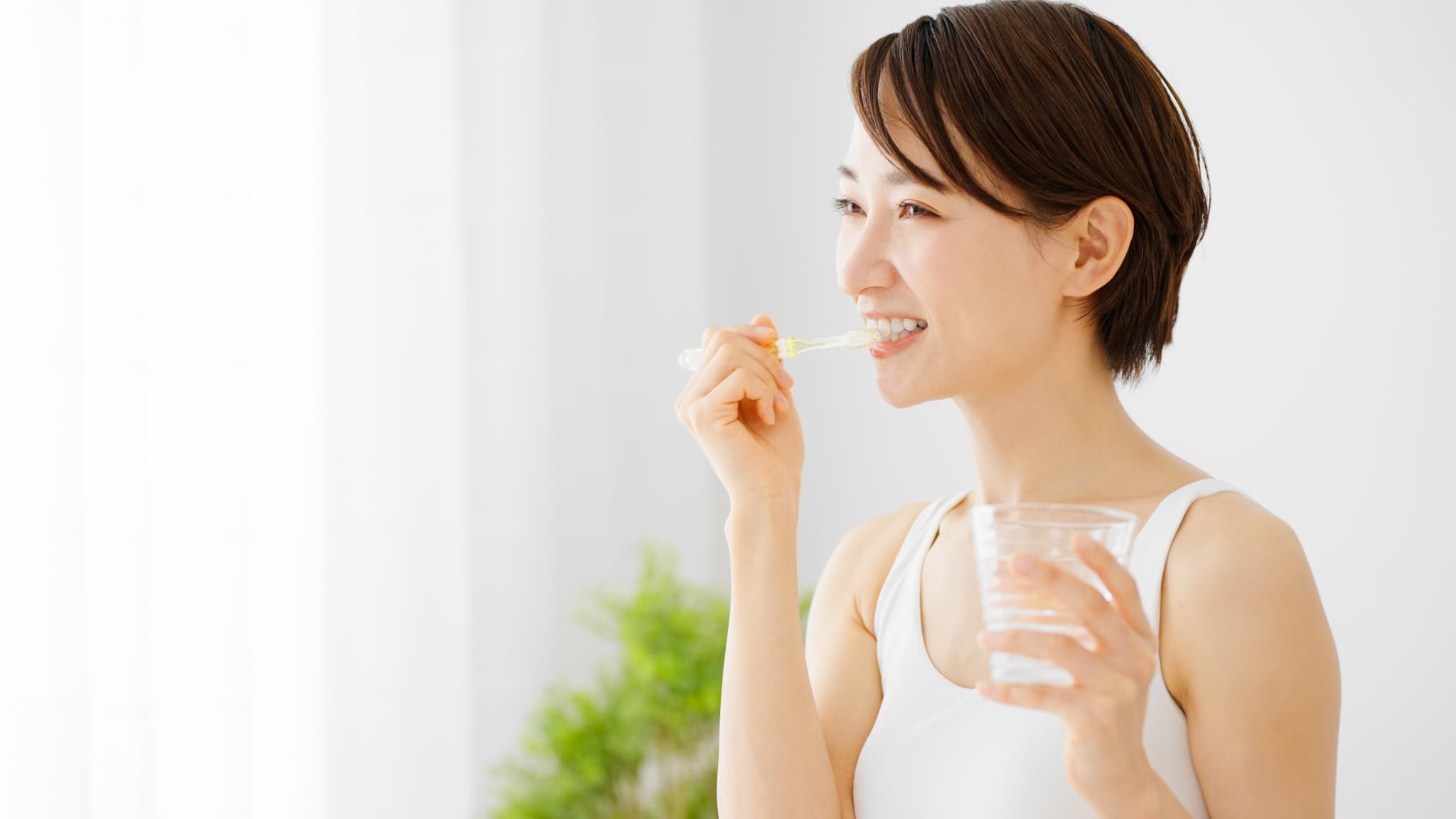 ホワイトニング後に丁寧に歯磨きする女性