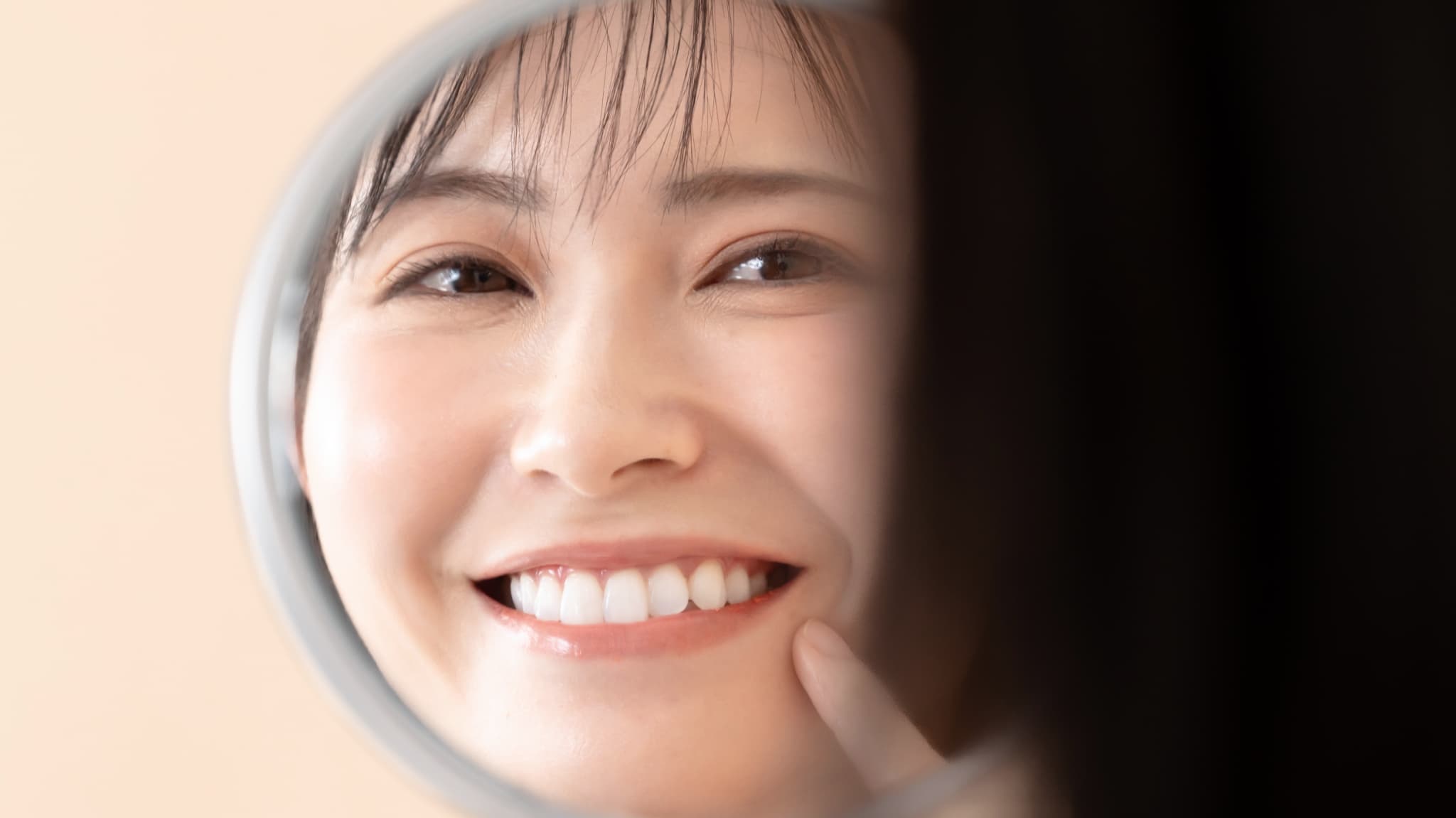 ホワイトニングで白くなった歯を見て嬉しそうな女性
