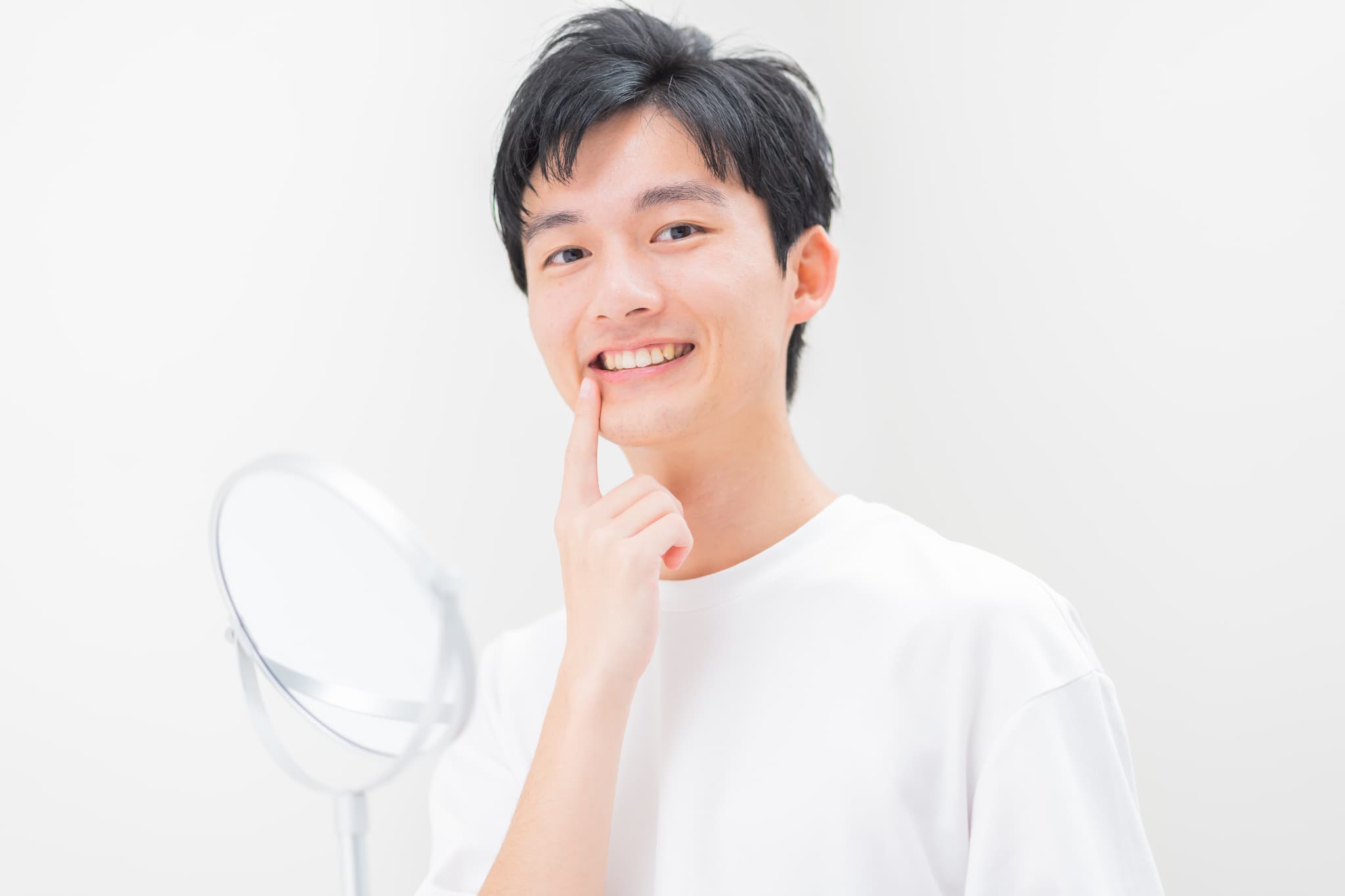 セラミックの歯を指さす男性