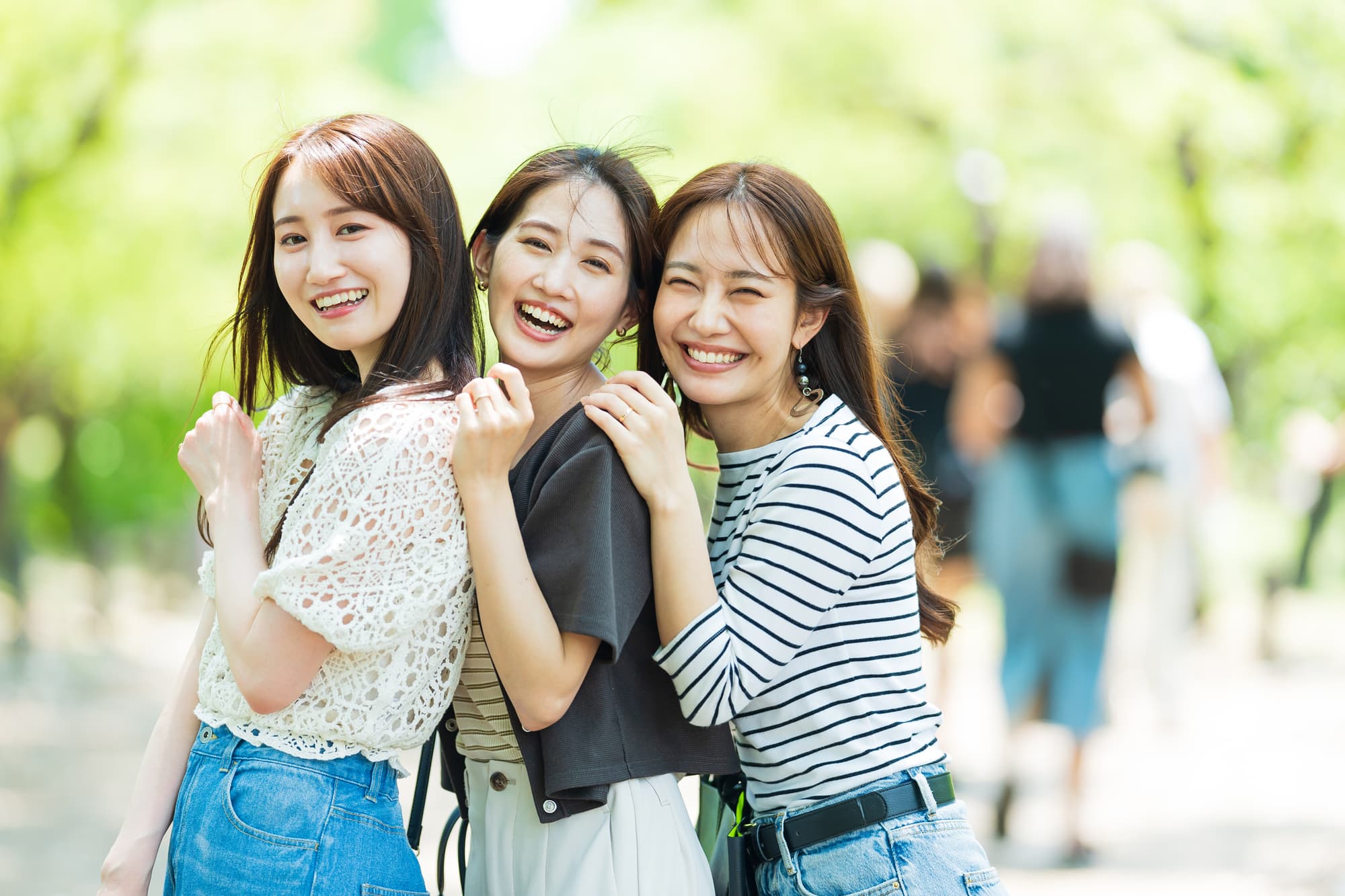 笑顔でくっつく三人の女性