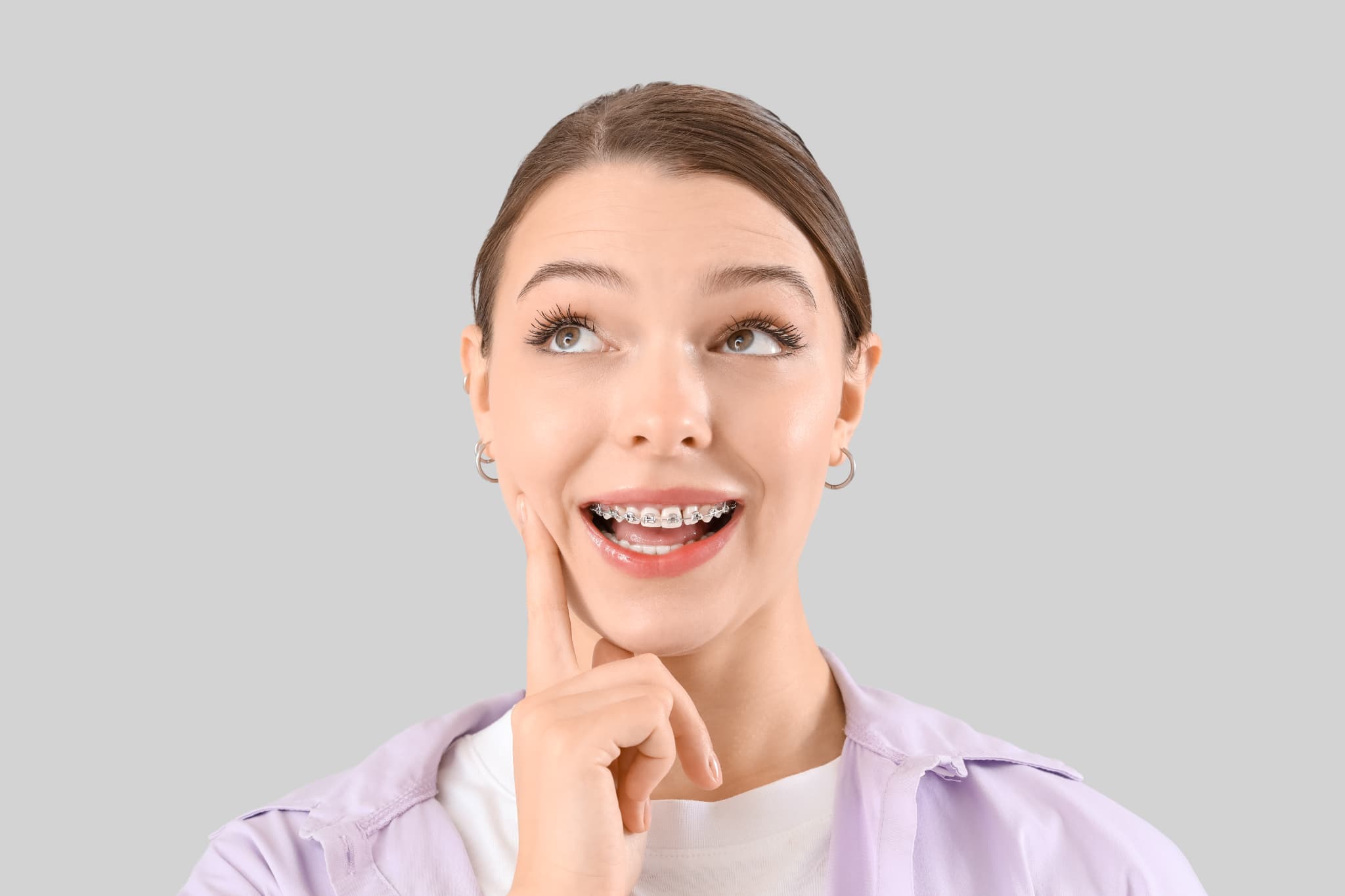 大人の歯列矯正はどれくらいかかるのか考えるワイヤー矯正中の女性