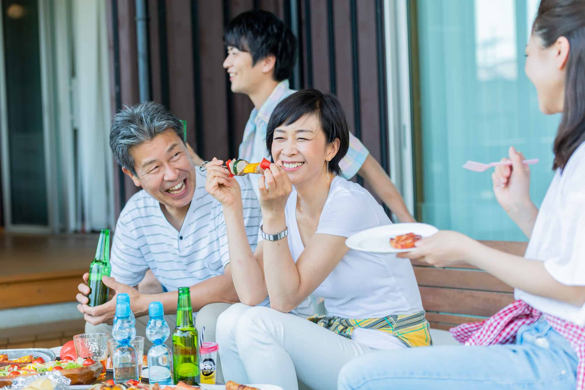 セラミックの歯の適切なケアで口臭が無くなった女性が仲間とバーベキューを楽しんでいるイメージ