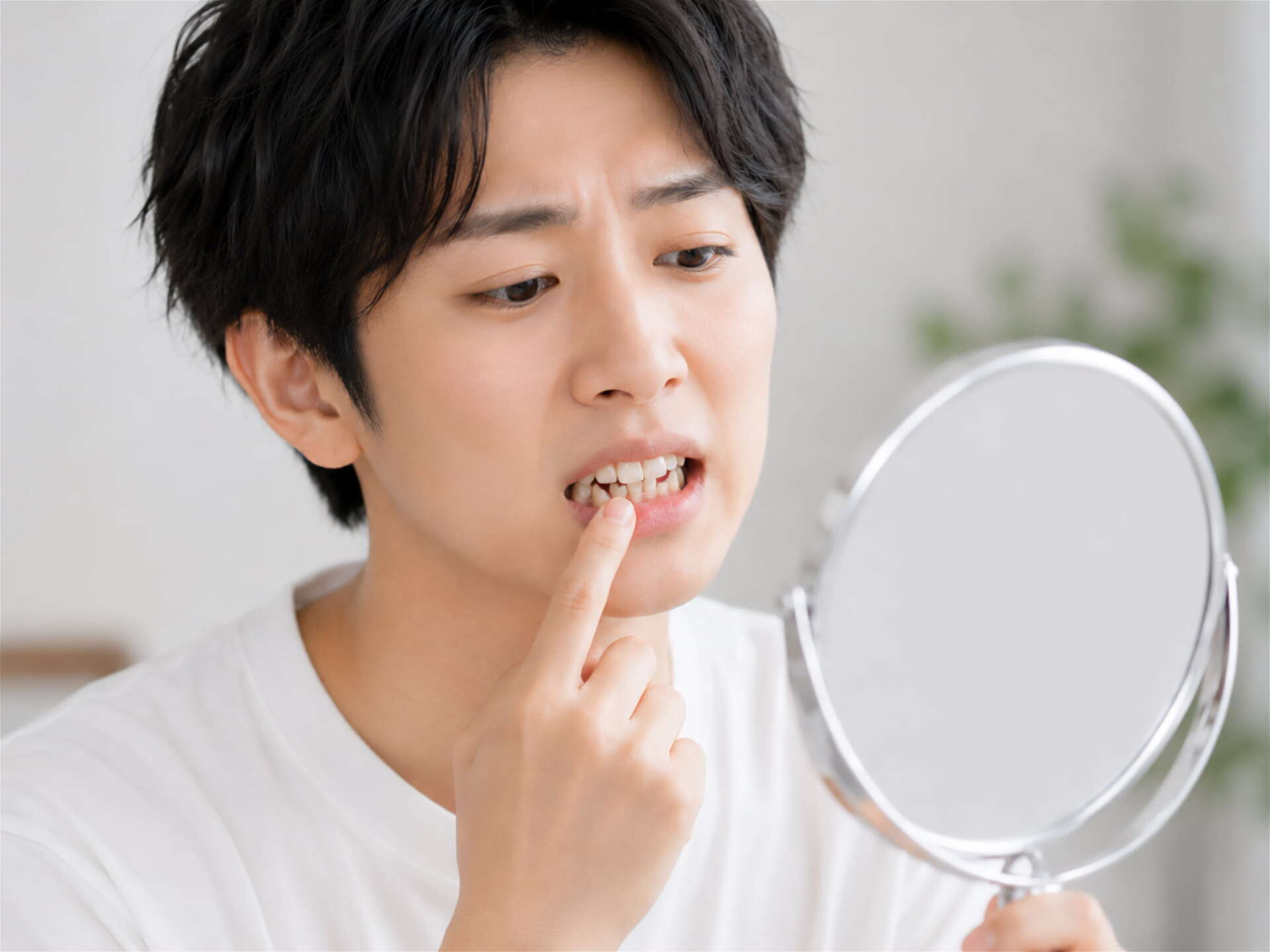 受け口を気にして鏡をみる男性